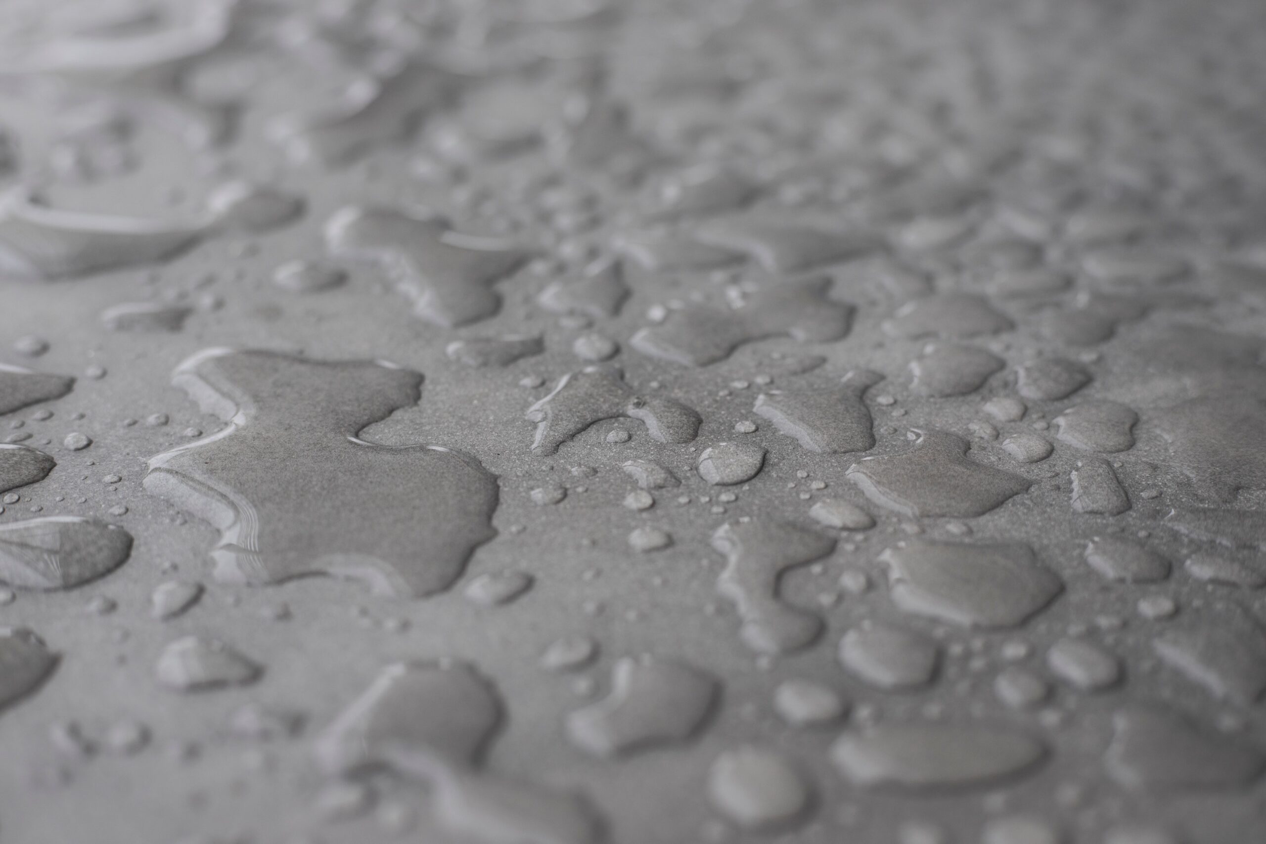 Water droplets beading on a polyaspartic-coated garage floor, showing moisture resistance
